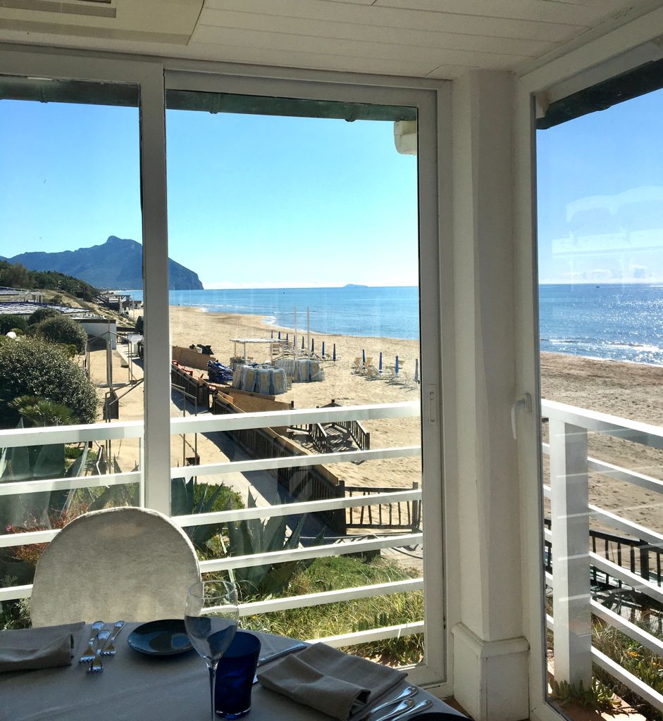 tavolo di un ristorante con vetrata vista mare e Monte Circeo