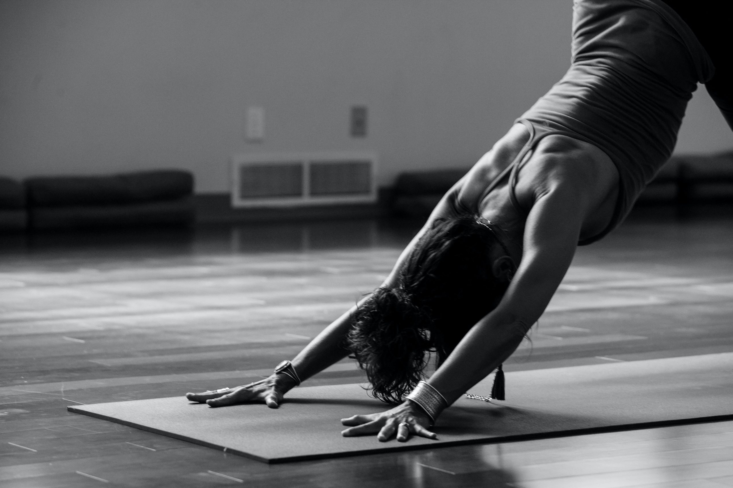 ragazza fa yoga posizione del cane a testa in giù in una sala yoga