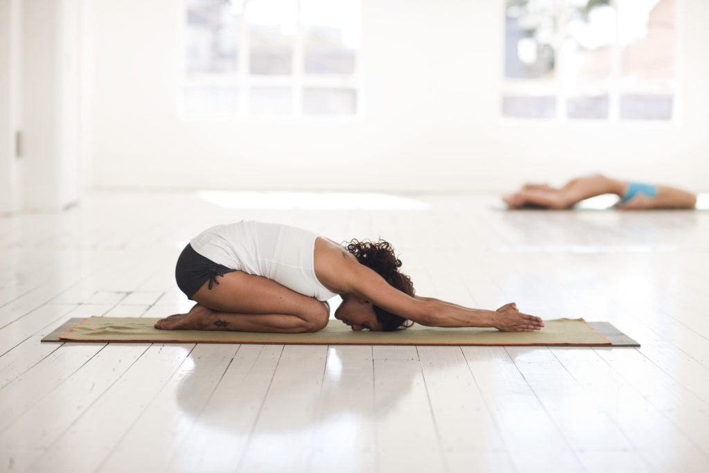 ragazza in posizione del bambino Balasana 