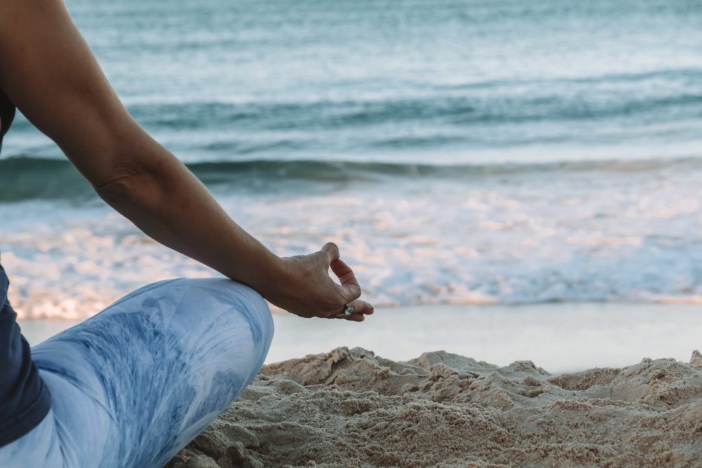 donna seduta in meditazione davanti al mare